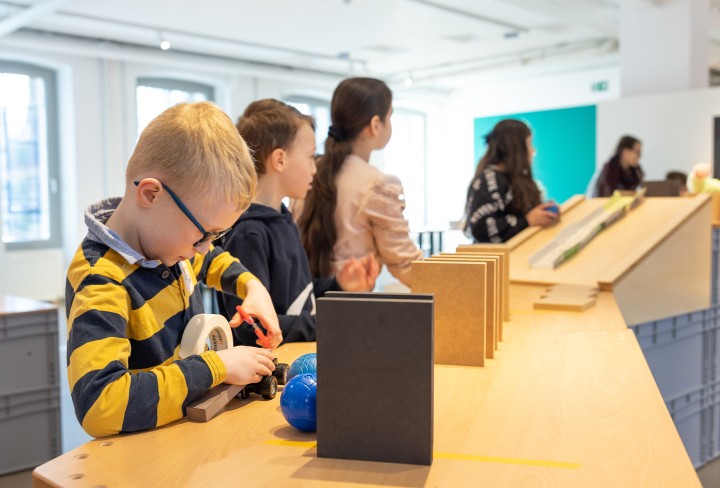 Kinder, die eine Kettenreaktion basteln.