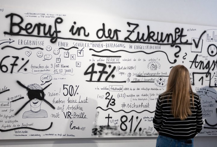 eine Frau vor einer Tafel mit der Ãberschrift 