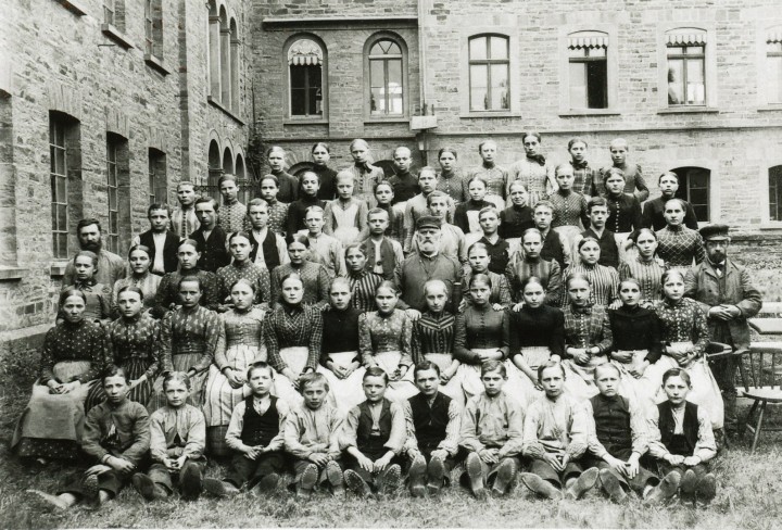 Historisches Schwarz-Weiss-Foto zeigt Mitarbeiter der Haspelei vor einem alten Gebäude