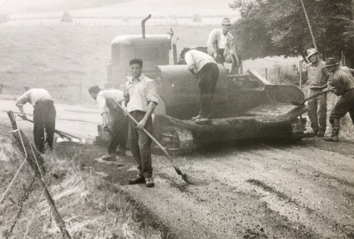 Altes Schwarz-Weiß Foto zeigt Bauarbeiter beim Straßenbau