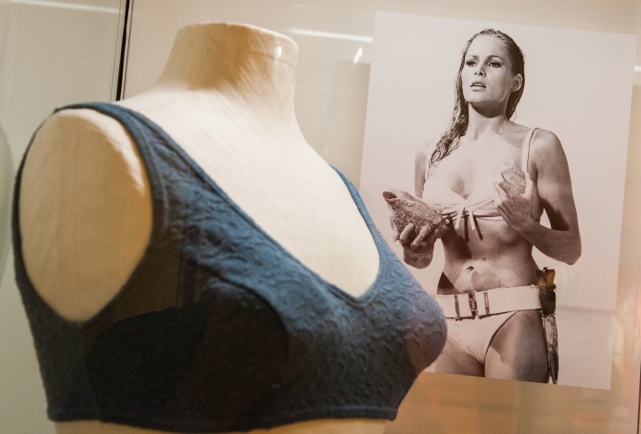 Dunkelblaues Bikinioberteil auf einer weißen Büste und im Hintergrund ein Foto von Ursula Andress