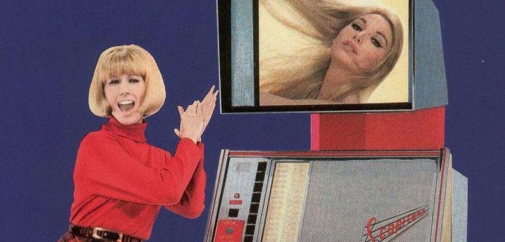 Eine böllonde Frau steht neben eineem Scoptione-Film-Automaten und klatscht in die Hände
