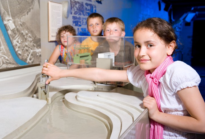 Eine Gruppe von Kindern experimentieren am Wasserkraftmodell.