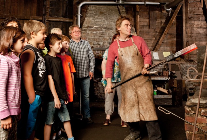 Children watch the blacksmith