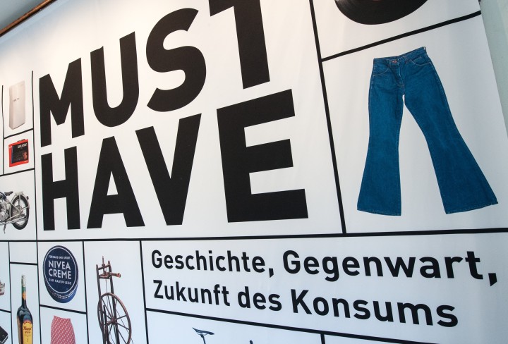 Ausstellungsgrafik mit der Aufschrift "Must-have. Geschichte, Gegenwart, Zukunft des Konsums"