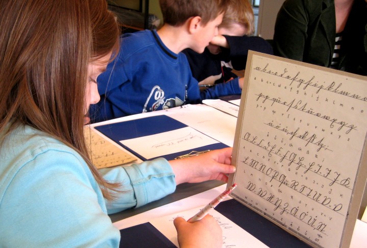 Young people write with ink and pen in "German script"