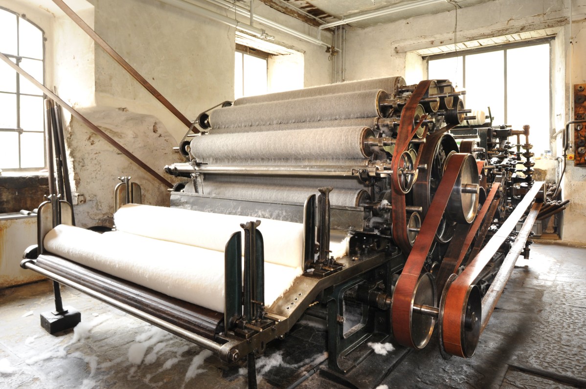 Maschine zur Vorgarnherstellung in der Krempelei, darauf feines Wollvlies