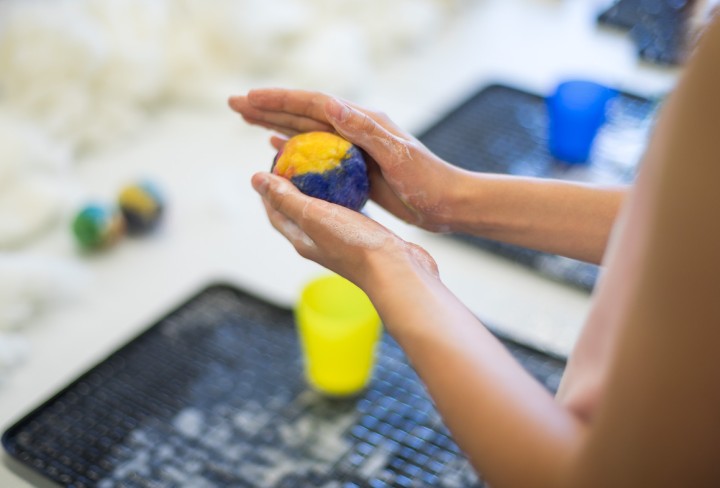 Hände formen einen Ball aus Wolle