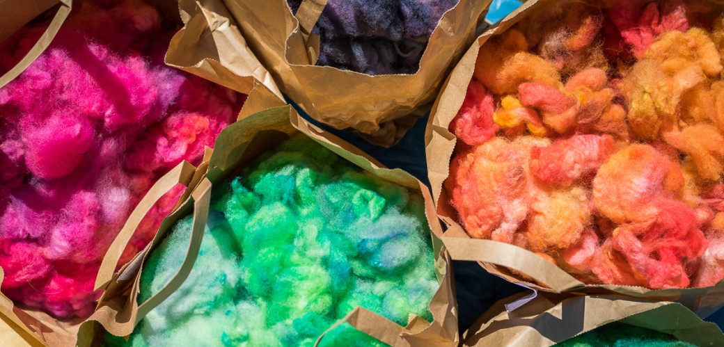 Bunte Wolle in Papiertüten.