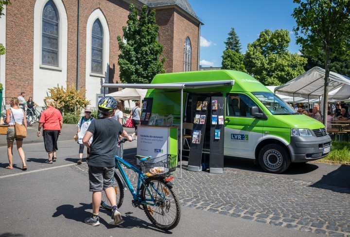 Bild eines grünen Kleinbusses auf einem Platz