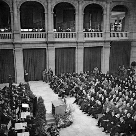 Das historische schwarz-weiß Foto, festgehalten von Erna Wagner-Hehmke, zeigt die Eröffnung der Beratungen des Parlamentarischen Rates am 1. September 1948 im Lichthof des Museums Alexander Koenig. Es findet ein Festakt statt, der vom Städtischen Orchester Bonn begleitet wurde.