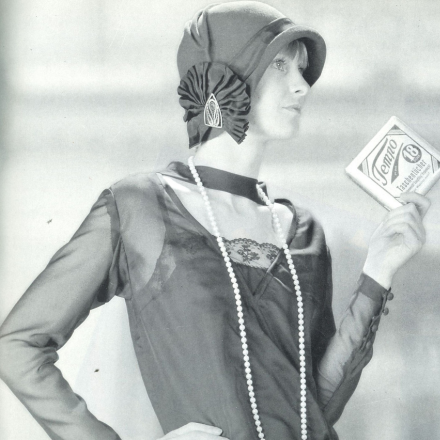 Schwarz/Weiß Foto einer Frau aus den 1930er Jahren, sie hält eine Packung Tempo Taschentücher in ihrer Hand