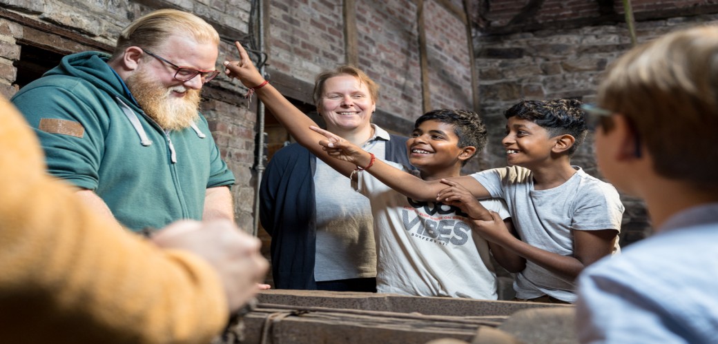 Illustration einer Schulklasse, in der sich junge Leute austauschen. An der Tafel ist eine Abstimmung zum Thema Schuluniform zu sehen. 