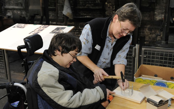 Woman in a wheelchair works together with a museum educator