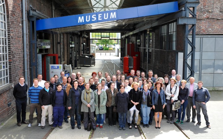  Group picture with many people in front of a sign saying "Museum"