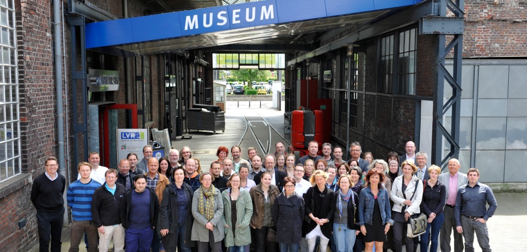 Group photo of museum employees in front of the label "Museum"