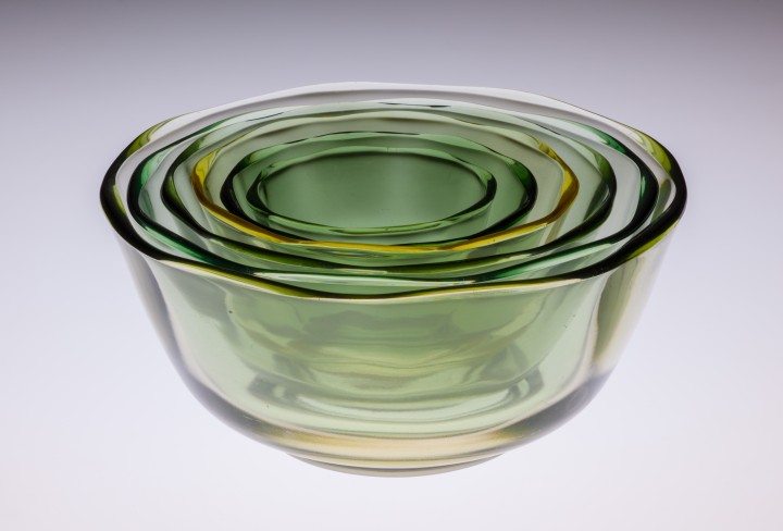 Ineinander gestapelte grüne Glasschalen nach dem Design von Wilhelm Wagenfeld.