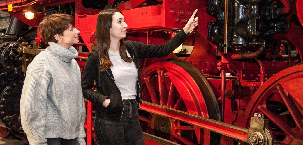 Zwei Damen an einer großen Lokomotive in der Ausstellung