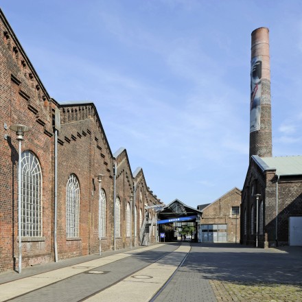 Außenansicht der Zinkfabrik Altenberg mit Gebäuden und einem Turm