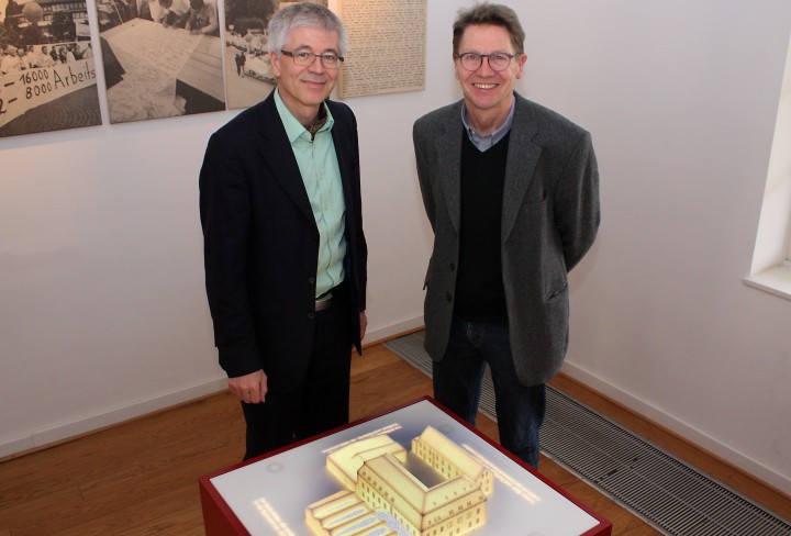 Zwei Männer stehen vor einem Tisch mit einem kleinen Modell der Tuchfabrik