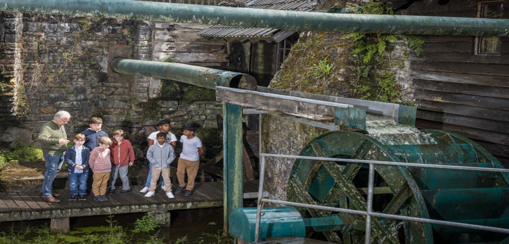 Mehrere aus Filz gefertigte Osterhasenfiguren in Braun- und Grautönen mit bunten Ostereiern auf einer hellen Unterlage