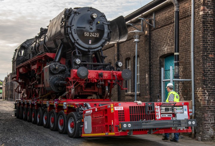 Eine Dampflokomotive auf einem Anhänger.
