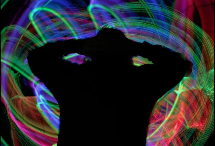 Foto von einer Person. Im Hintergrund sind bunte Lichter zu sehen.