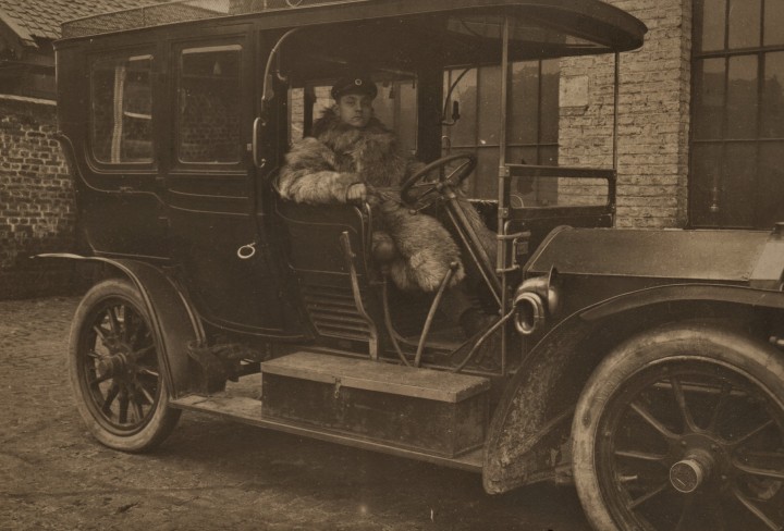 Historisches Foto von einem alten Auto in dem ein Mann sitzt