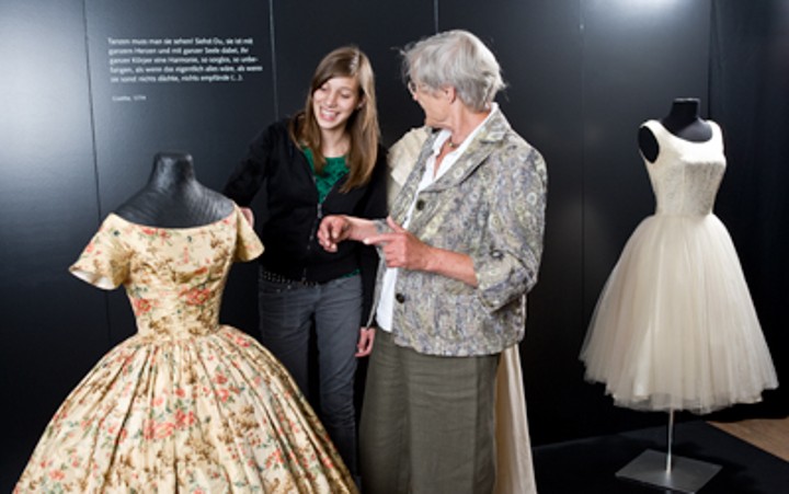 Großmutter und Enkelin bestaunen historisches Kleid