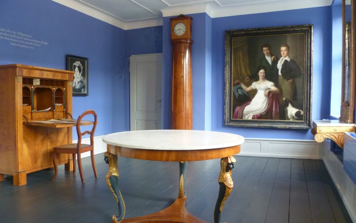 Glance into a room with paintings and period furniture