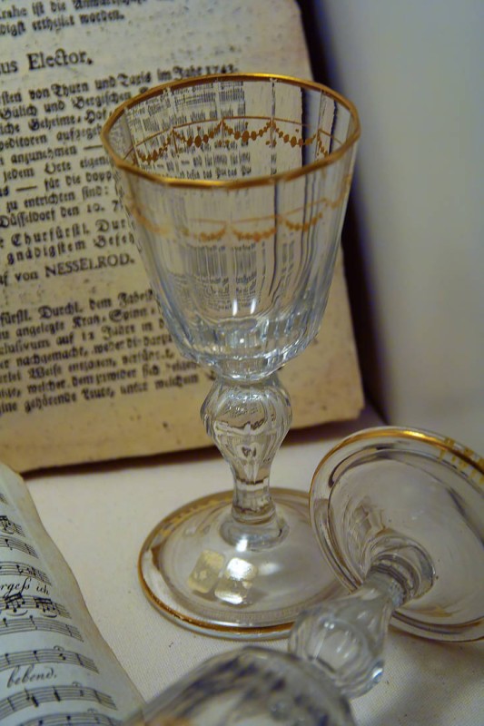 Objects in a display case in the Cromford Manor's permanent exhibition: glasses and historical documents