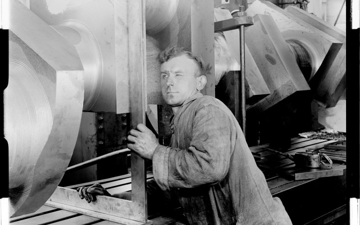 Schwarz-weiß-Fotografie eines Arbeiters an einer Maschine
