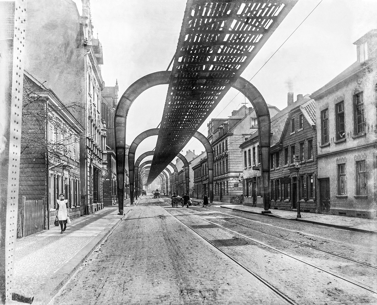 Historisches Schwarzweiß-Foto von Schwebebahn Konstrukt über einer Straße