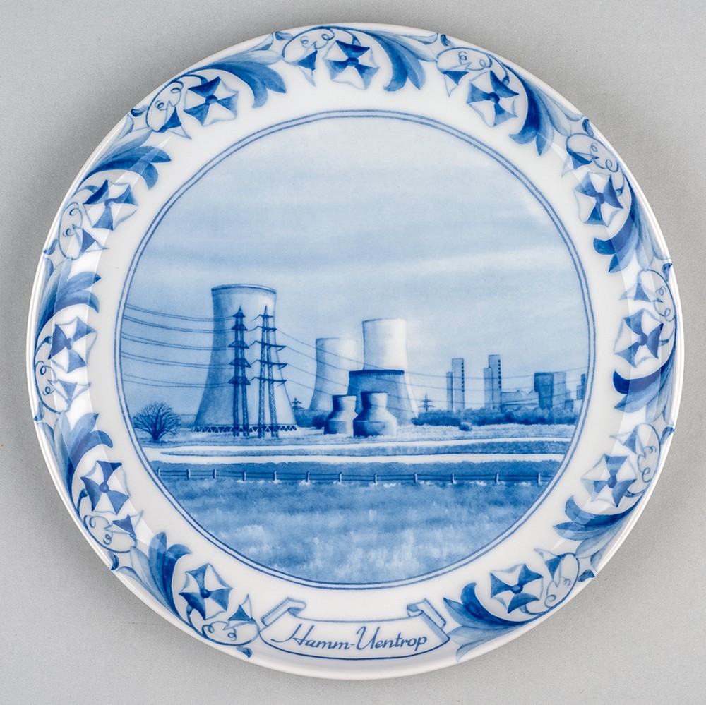 Weißer Teller mit blauer Zeichnung eines Atomkraftwerks