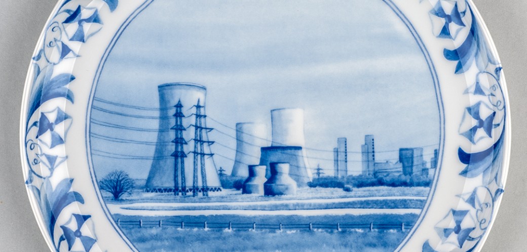Weißer Teller mit blauer Zeichnung eines Atomkraftwerks