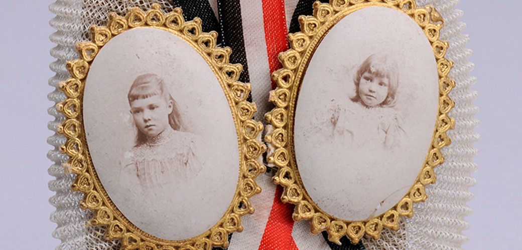 Schokoladentafel geschmückt mit Stoffbändern in den Farben Schwarz-Weiß-Rot und zwei goldgerahmten Medaillons mit Kinderfotos
