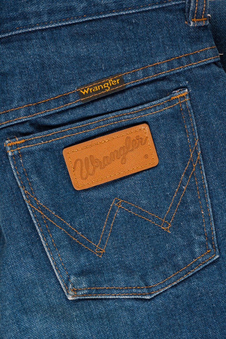 Hintere Hosentasche aus blauem Jeansstoff mit aufgenähtem Leder-Patch der Marke Wrangler
