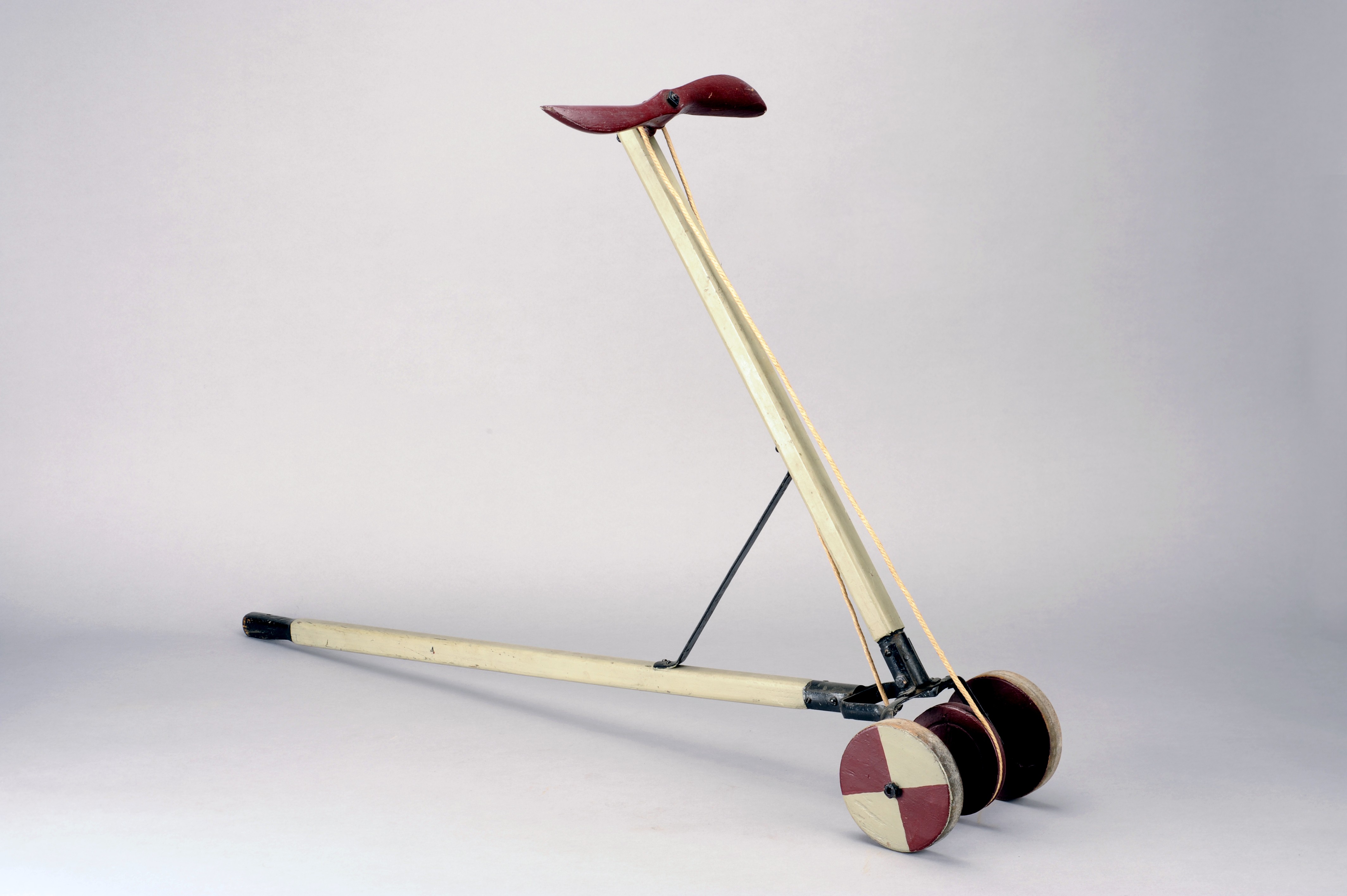 Grau gestrichenes Laufrad mit rotem Propeller aus Holz