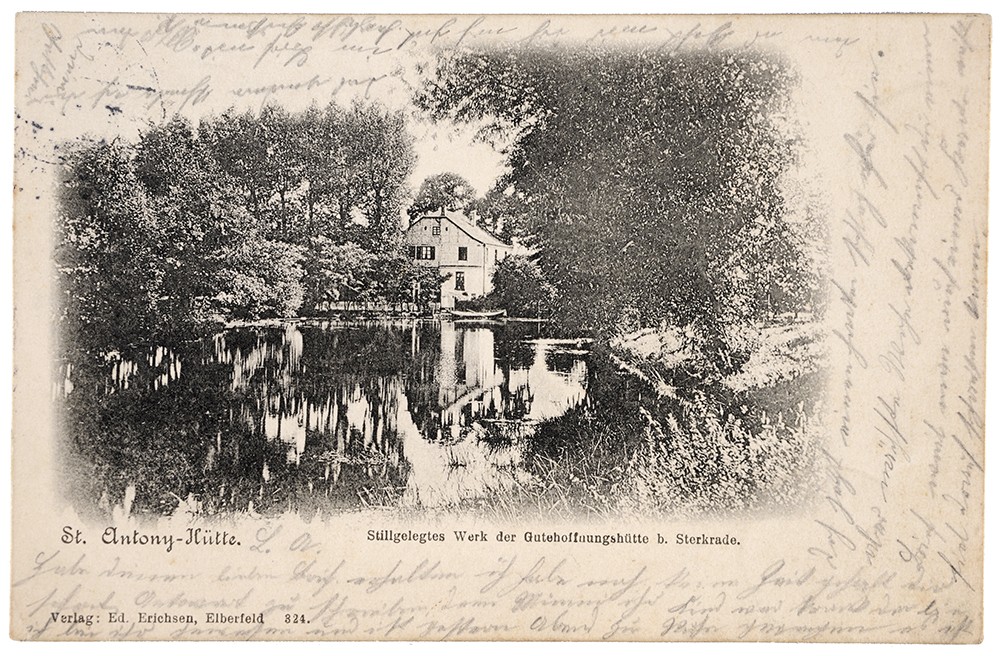 Vorderseite einer Postkarte mit idyllischem Teich und Fachwerkhaus