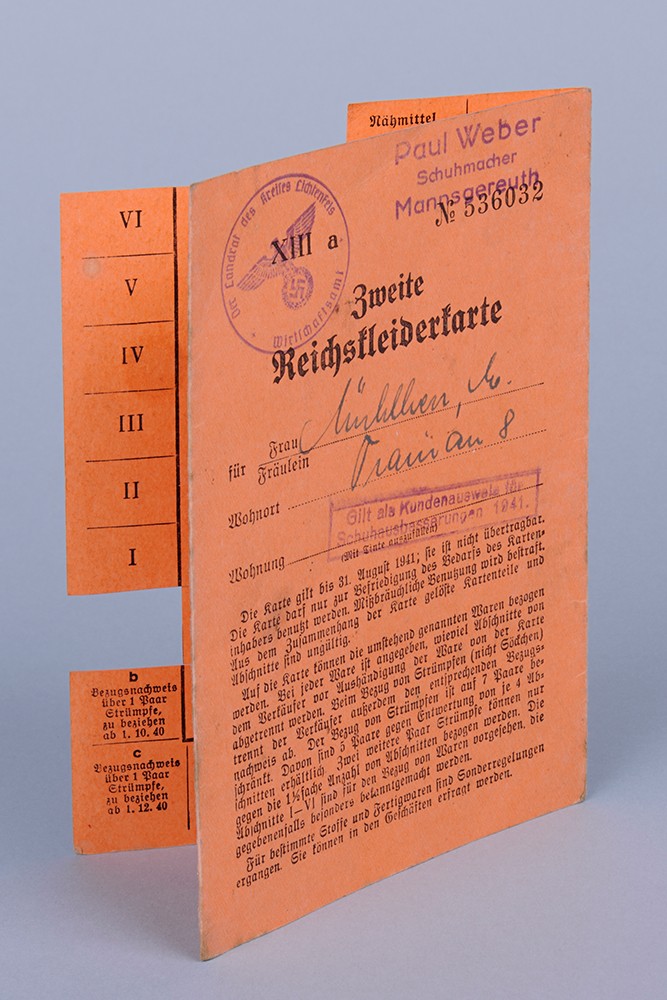 Eine gestempelte Reichskleiderkarte, gedruckt auf roter Pappe