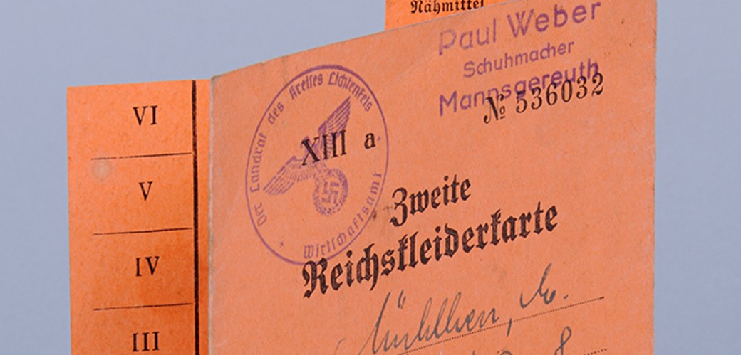 Eine gestempelte Reichskleiderkarte, gedruckt auf roter Pappe