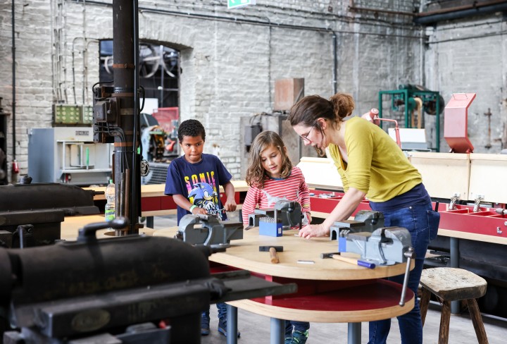 Eine Familie die am Werkzeugtisch werkelt