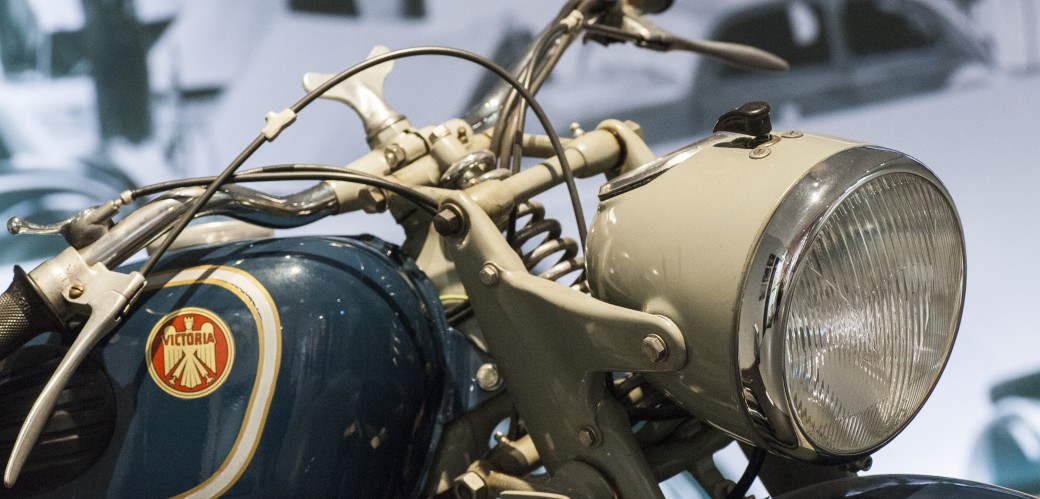 Detailaufnahme eines historischen Motorrads mit Lenker und Scheinwerfer