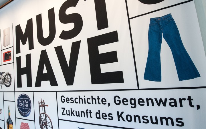 Ausstellungsbanner mit der Aufschrift "Must-have. Geschichte, Gegenwart, Zukunft des Konsums"