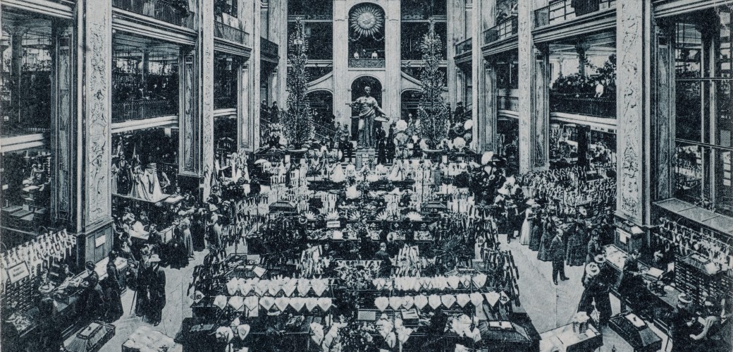 Schwarz-Weiß-Fotografie eines opulenten Warenhauses mit vielen Kunden