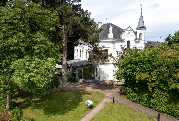 Luftbild einer Villa zwischen grünen Bäumen