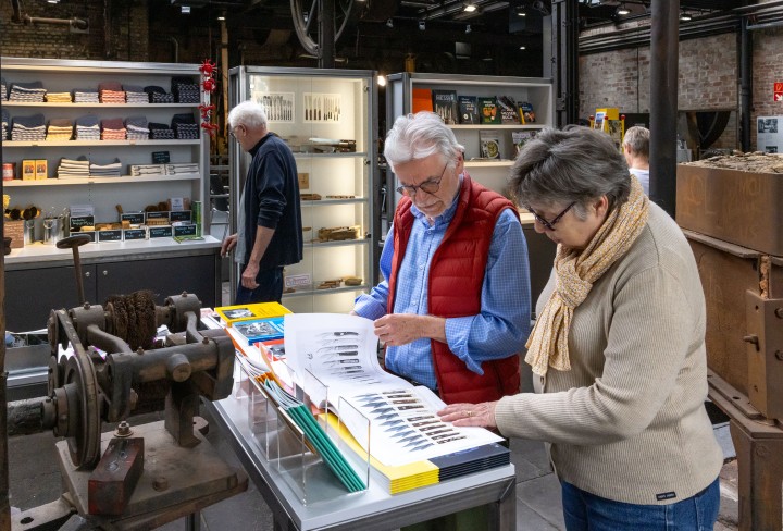 Besuchende blättern durch ein Buch im Museumsshop