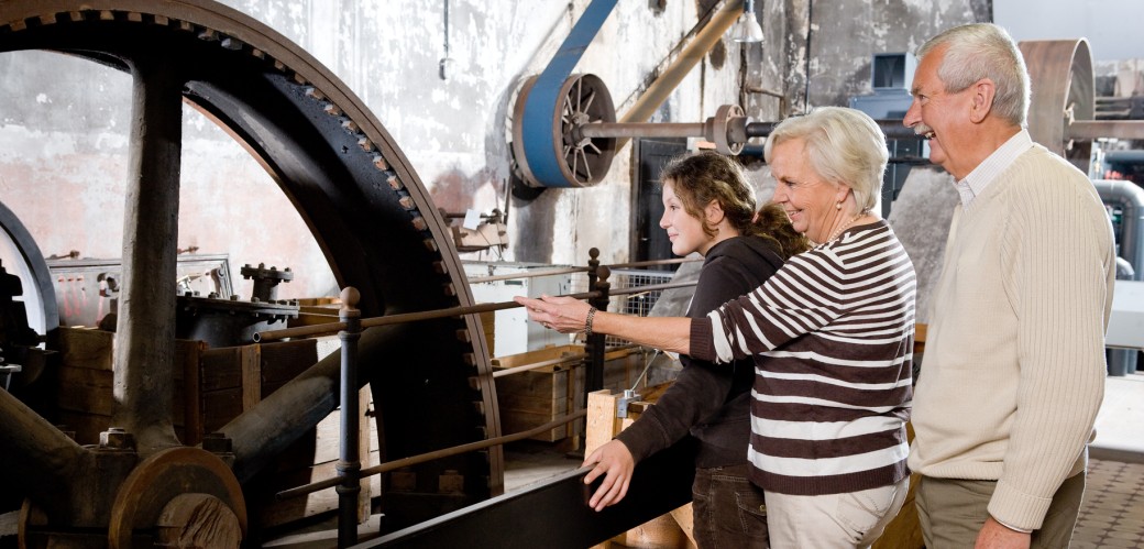Girls with grandparents on a large flywheel