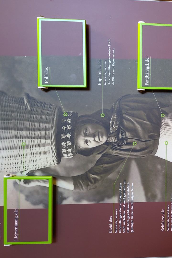 Blick auf ein historisches Foto einer Frau mit einem Weidekorb auf dem Kopf
