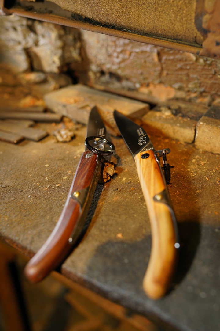 Zwei aufgeklappte Taschenmesser mit Holzgriffen